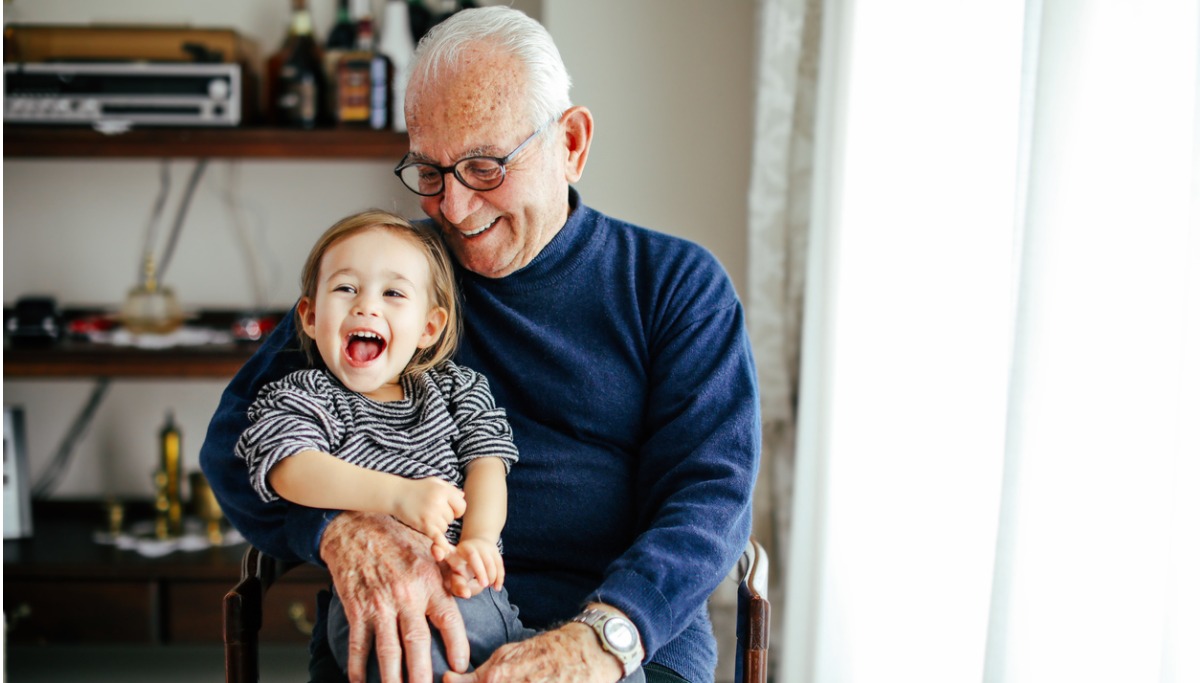 A grandfather holding his granddaughter