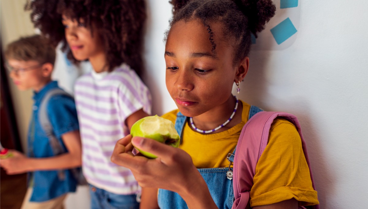 A young teen eating an apple