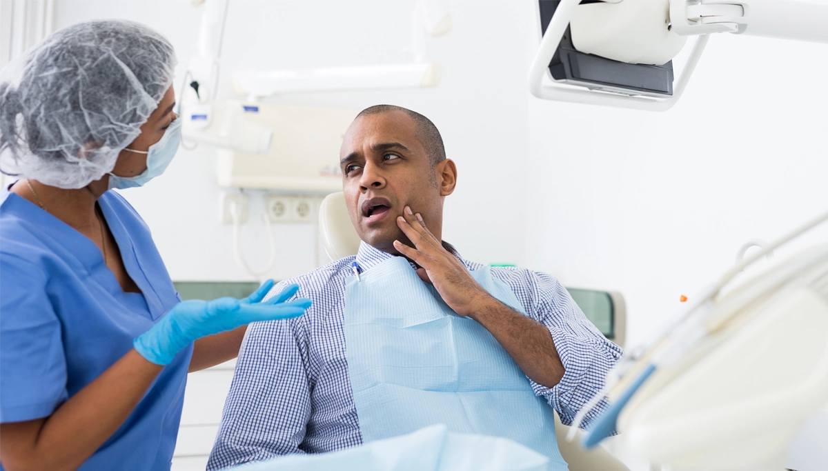A patient touching his mouth in pain