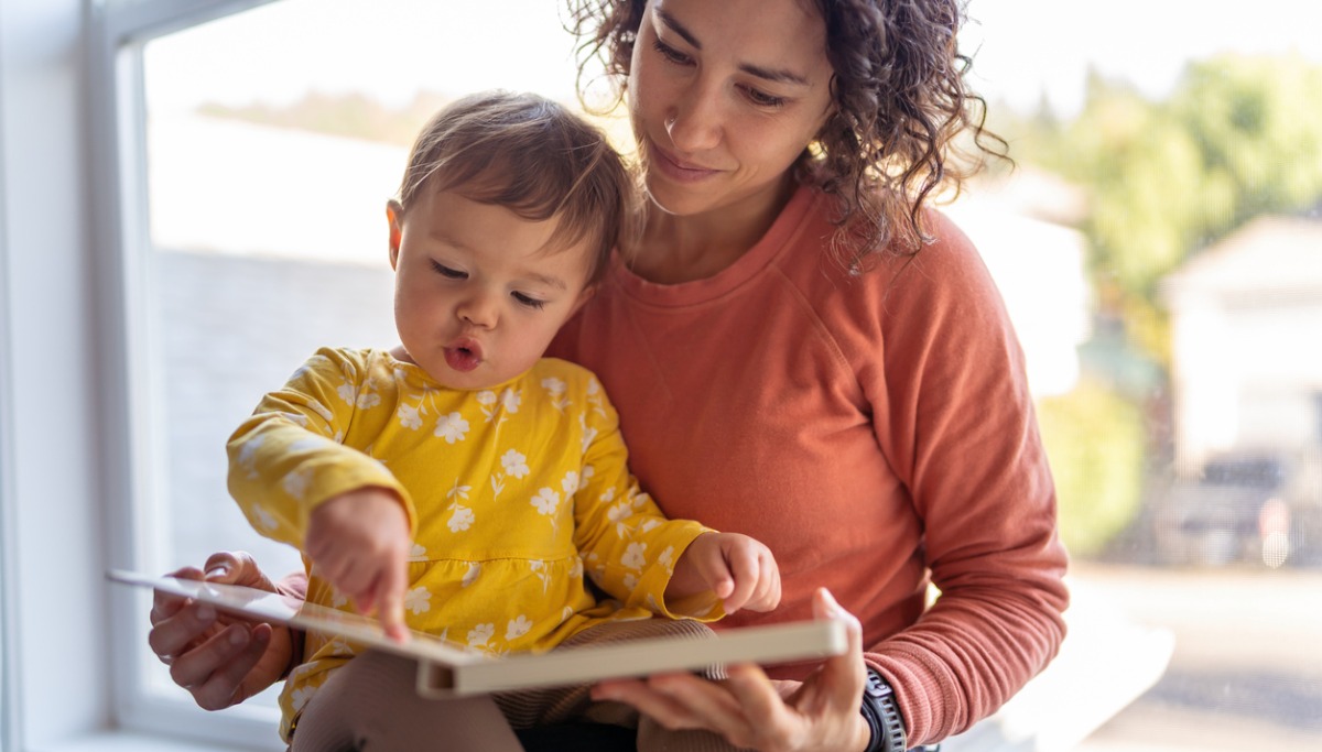 A mother reading a book to a toddler