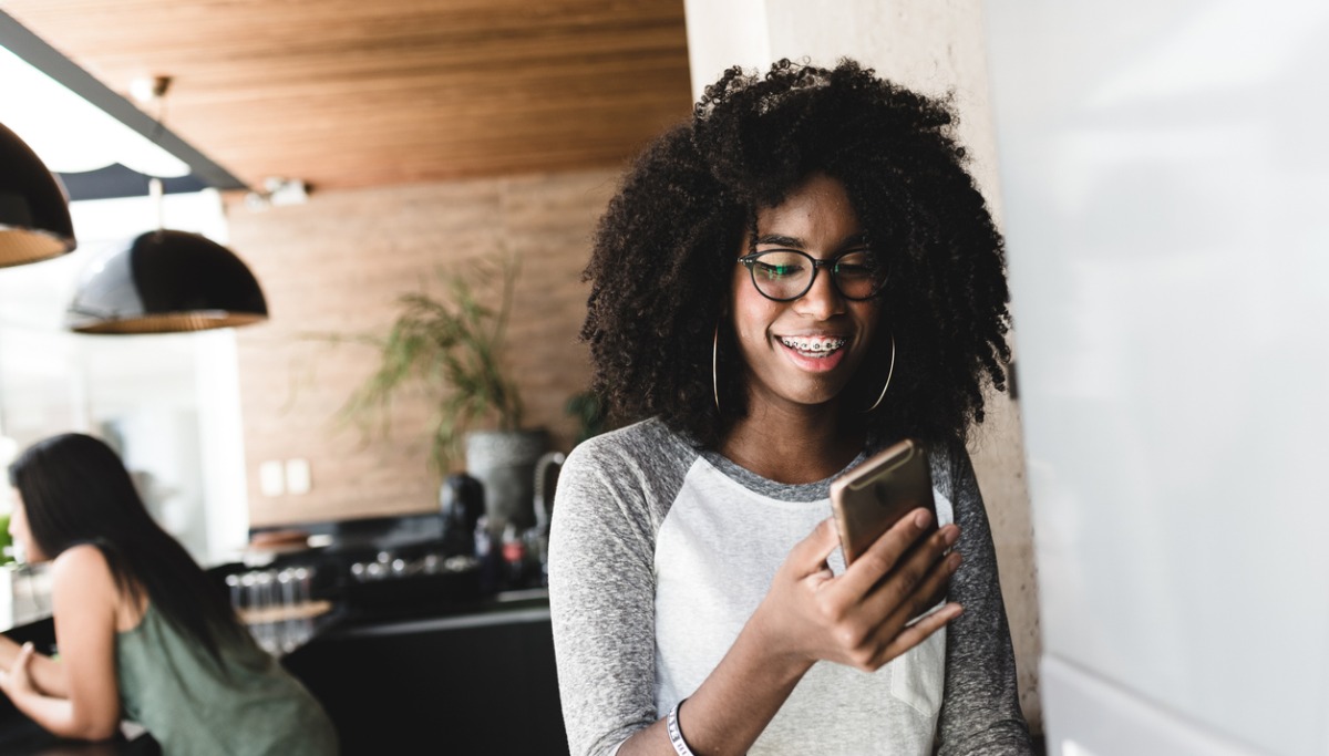 A girl with braces looking at her phone