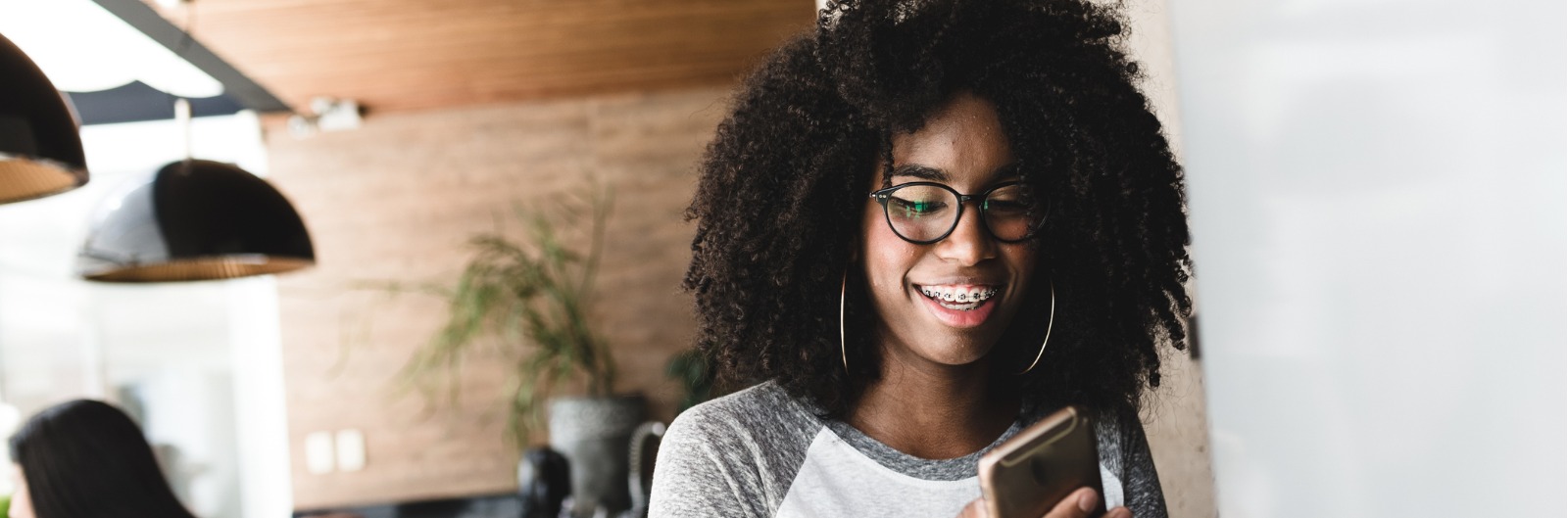 A girl with braces looking at her phone