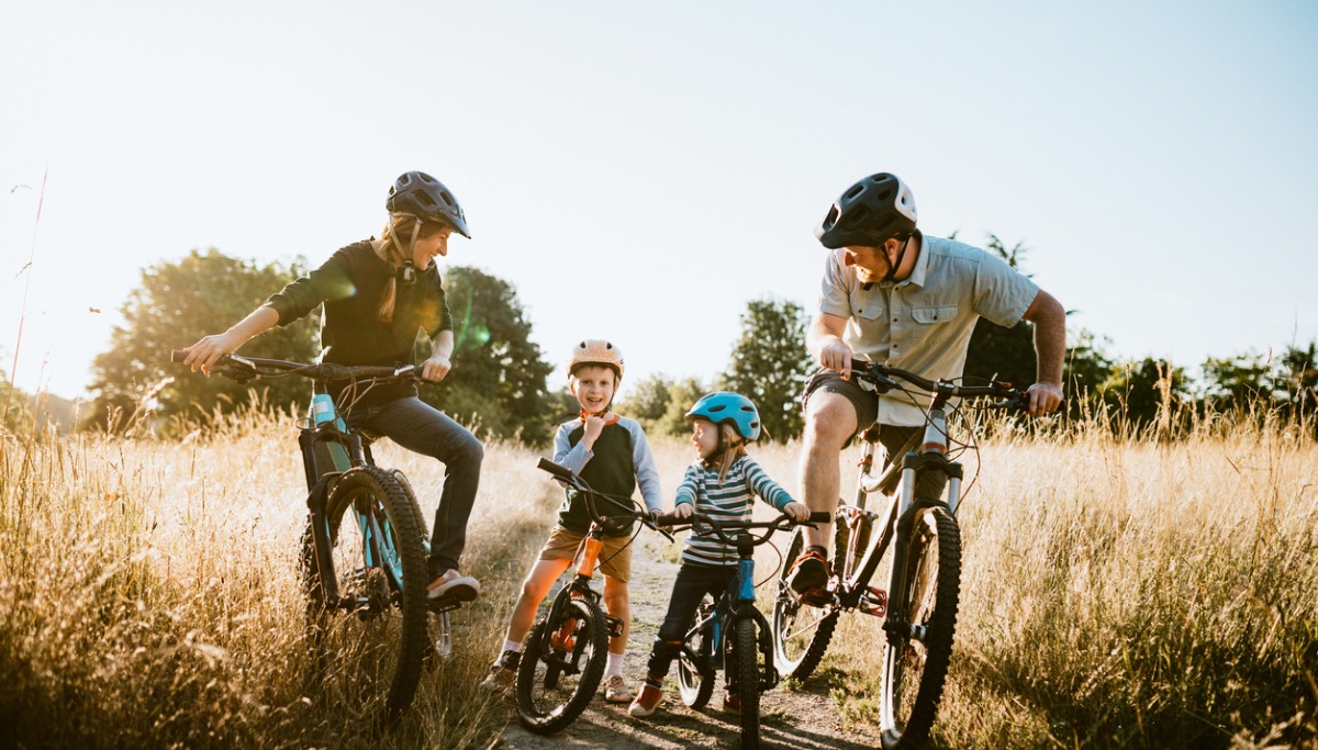 A family laughing and riding mountain bikes.
