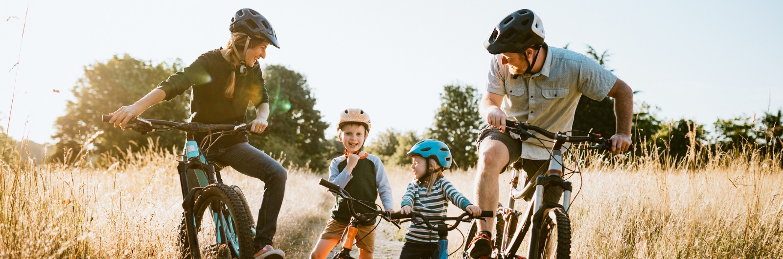 A family laughing and riding mountain bikes.
