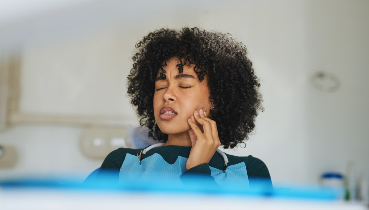 A women touching her jaw in pain
