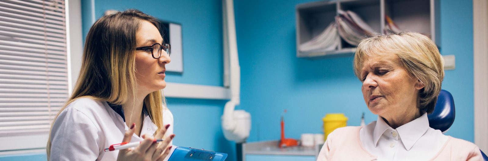 A dentist talking with a patient who is pain