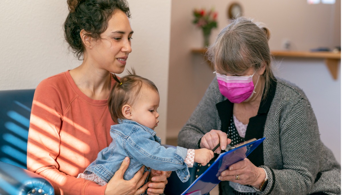 A mother and childen sitting with office staff