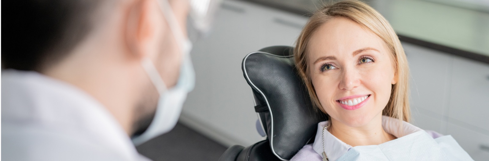 A patient looking at a dentist and smiling