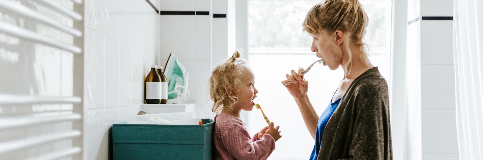A mother and child brushing their teeth