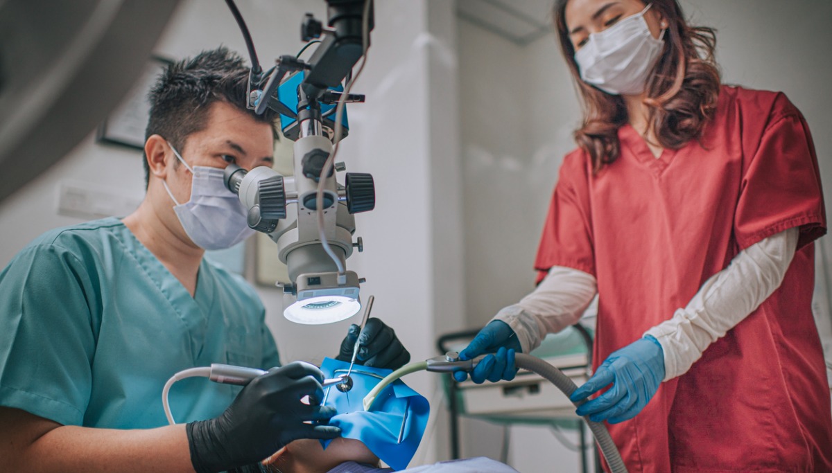 A dentist and assistant conducting a root canal