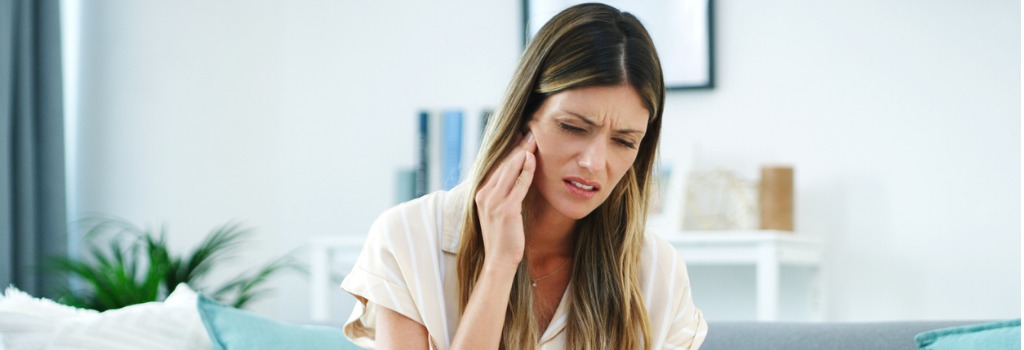 A woman holding her jaw in pain
