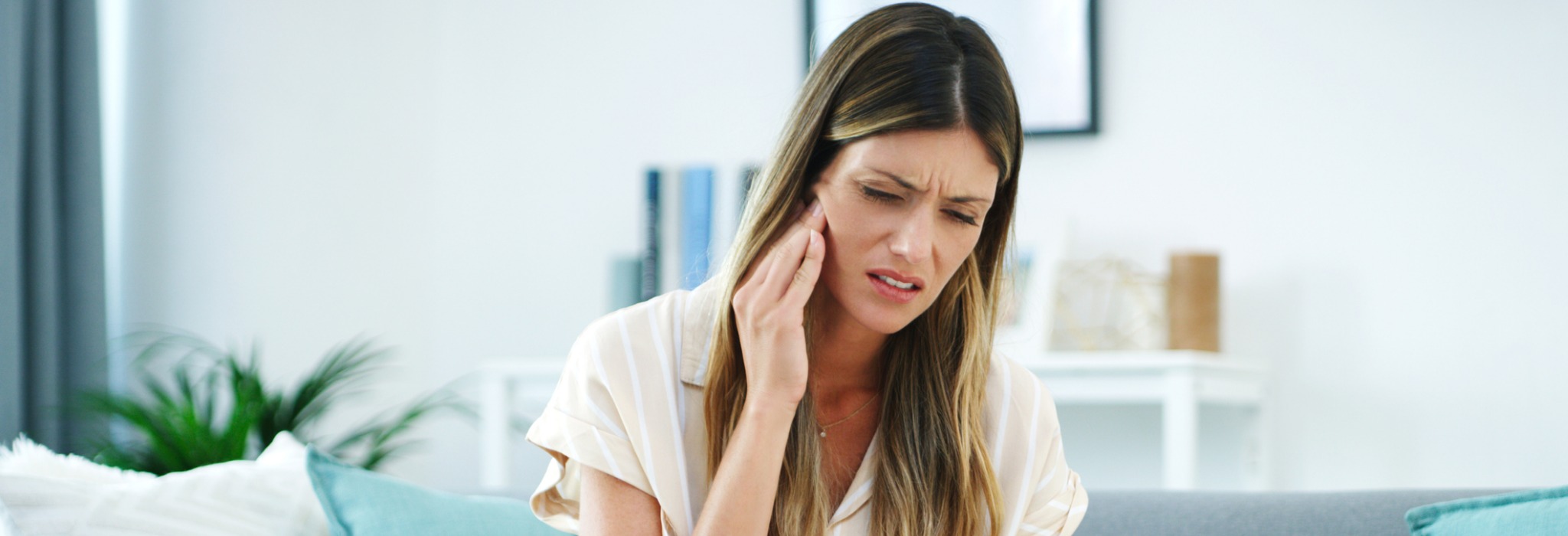 A woman holding her jaw in pain