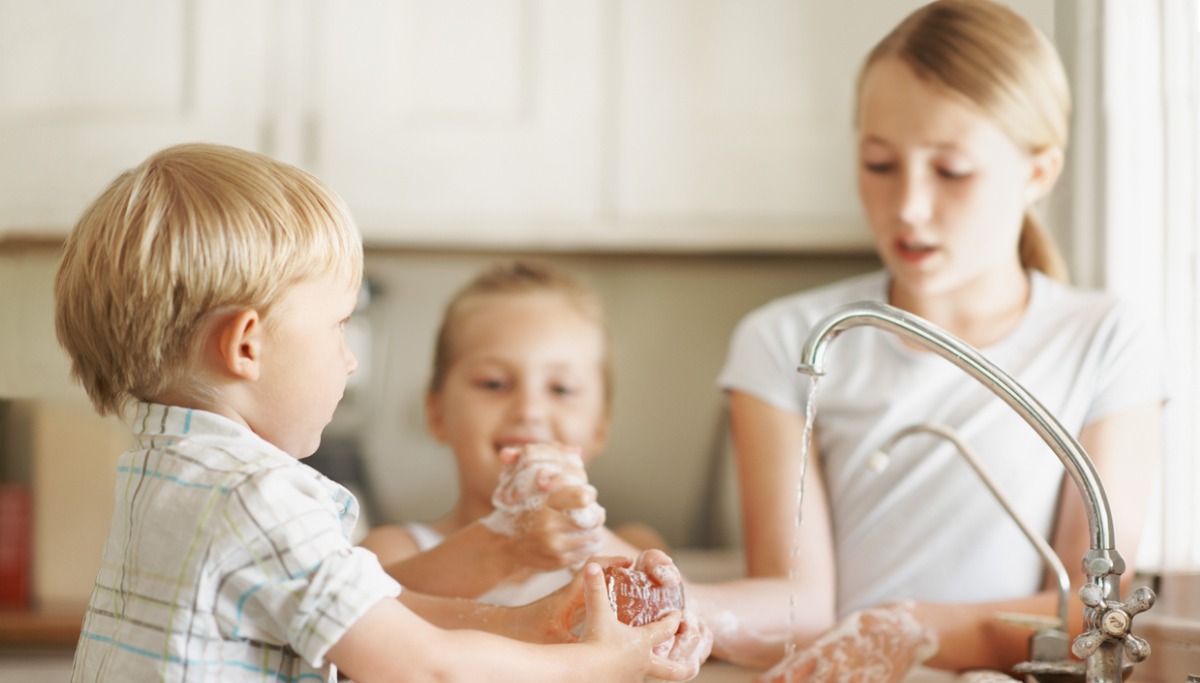 Three children washing their hands