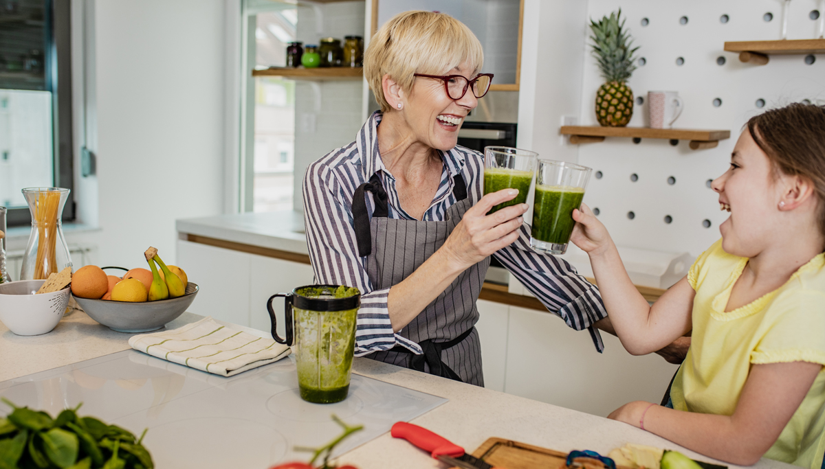 A grandmother drinking a smoothie with her granddaughter