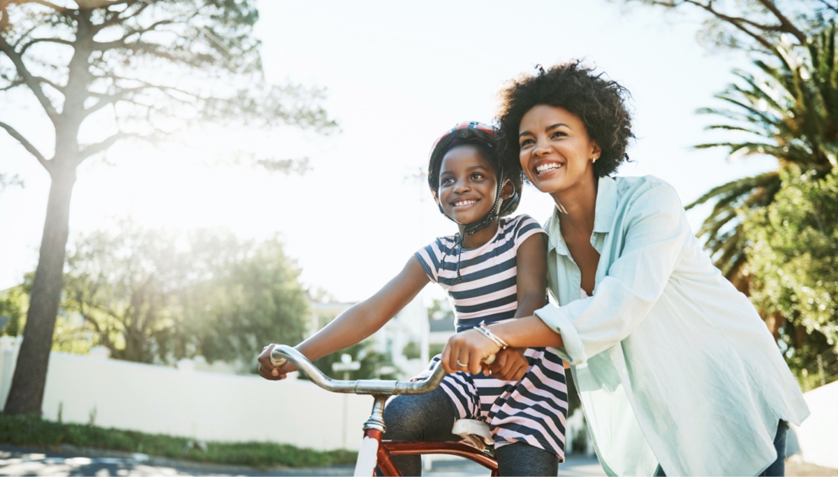 A mother teaching her daughter how to ride a bike