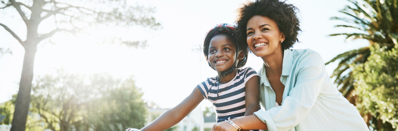 A mother teaching her daughter how to ride a bike