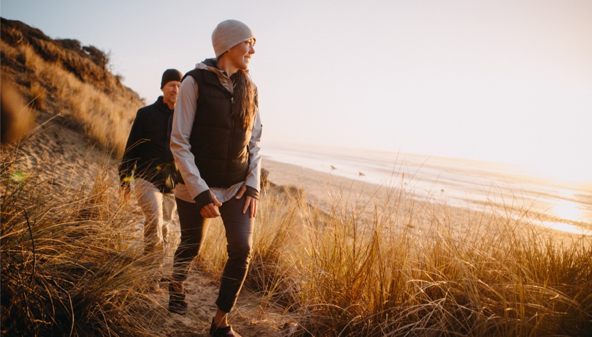 A couple walking along a natural beach