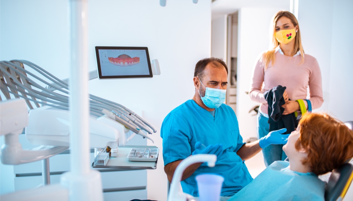 A mother and son talking to a dentist