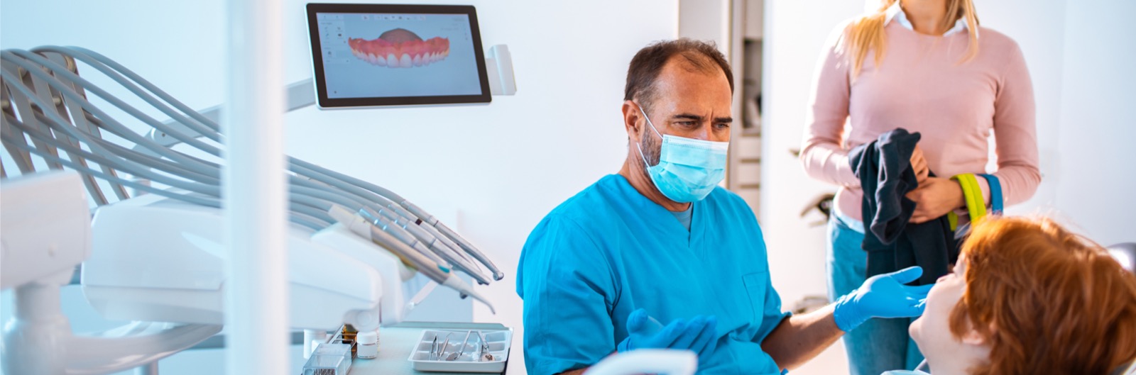 A mother and son talking to a dentist