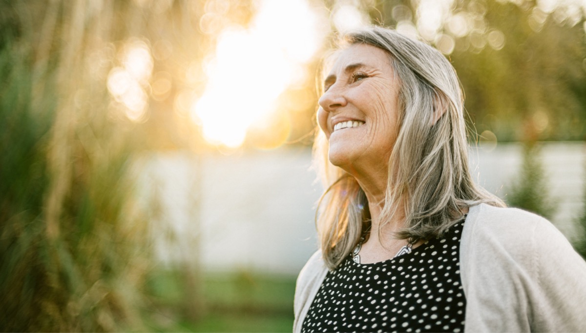 A woman smiling outside in the sun